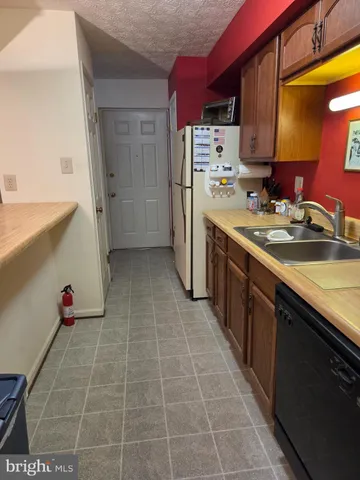 a kitchen with stainless steel appliances a sink stove and refrigerator