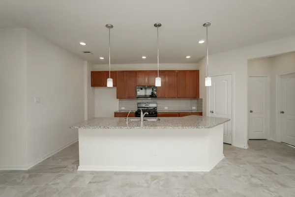 a large kitchen with kitchen island a sink stainless steel appliances and a counter top
