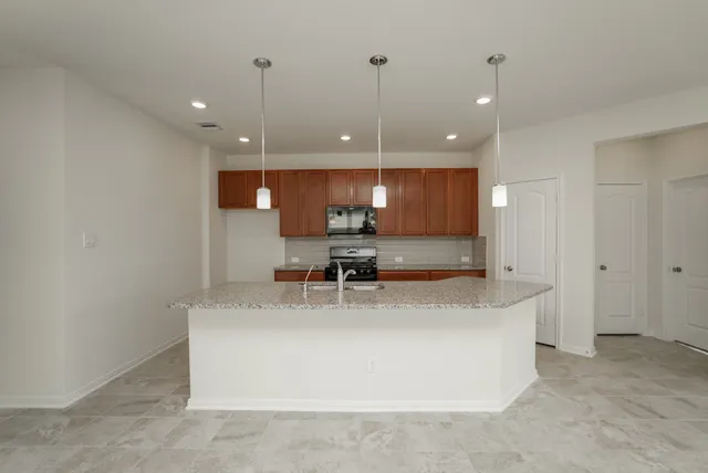 a large kitchen with kitchen island a sink stainless steel appliances and a counter top