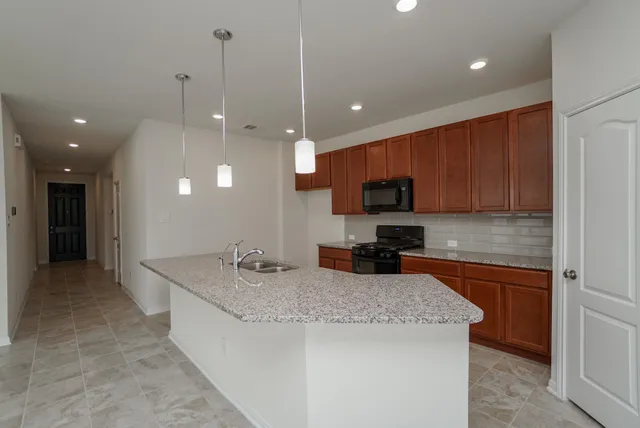 a kitchen with stainless steel appliances granite countertop a sink stove and refrigerator