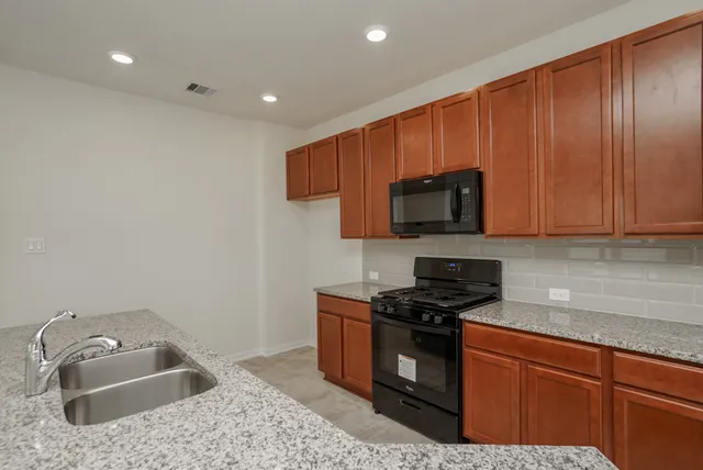 a kitchen with stainless steel appliances granite countertop a sink stove and microwave