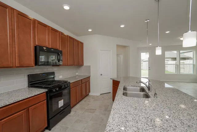 a kitchen with stainless steel appliances granite countertop a sink stove and microwave