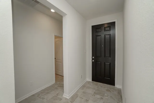an empty room with windows and closet area