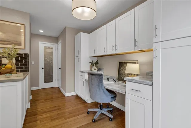 a view of a workspace with furniture and wooden floor