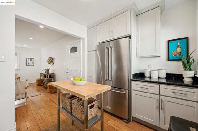 a kitchen with stainless steel appliances a refrigerator a sink a stove and white cabinets