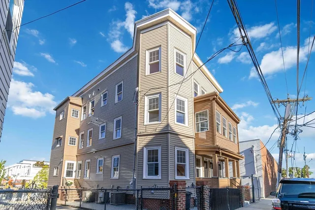 a front view of a residential apartment building with a yard
