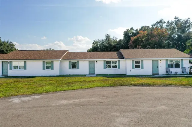 a front view of a house with a yard and trees