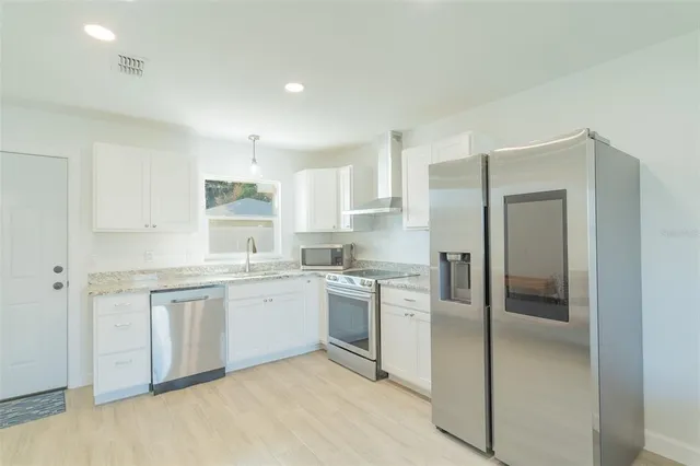 a kitchen with a refrigerator sink and cabinets