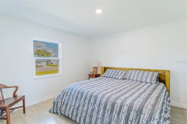 a bedroom with a bed and painting on the wall