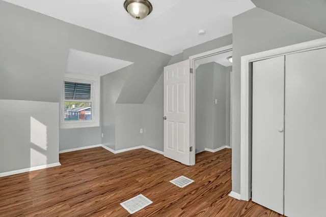 a bedroom with a bed and wooden floor