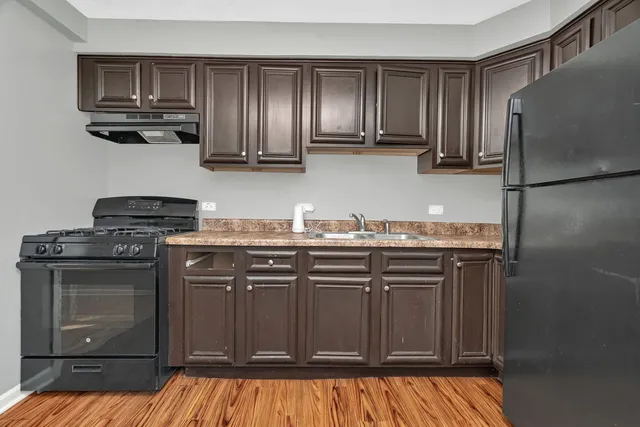 a kitchen with stainless steel appliances granite countertop a refrigerator and a stove top oven