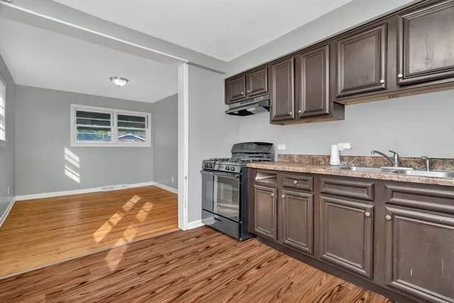 a kitchen with granite countertop wooden cabinets stainless steel appliances and a sink