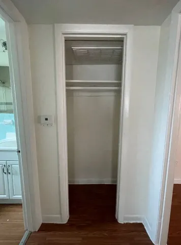 a view of walk in closet with wooden floor