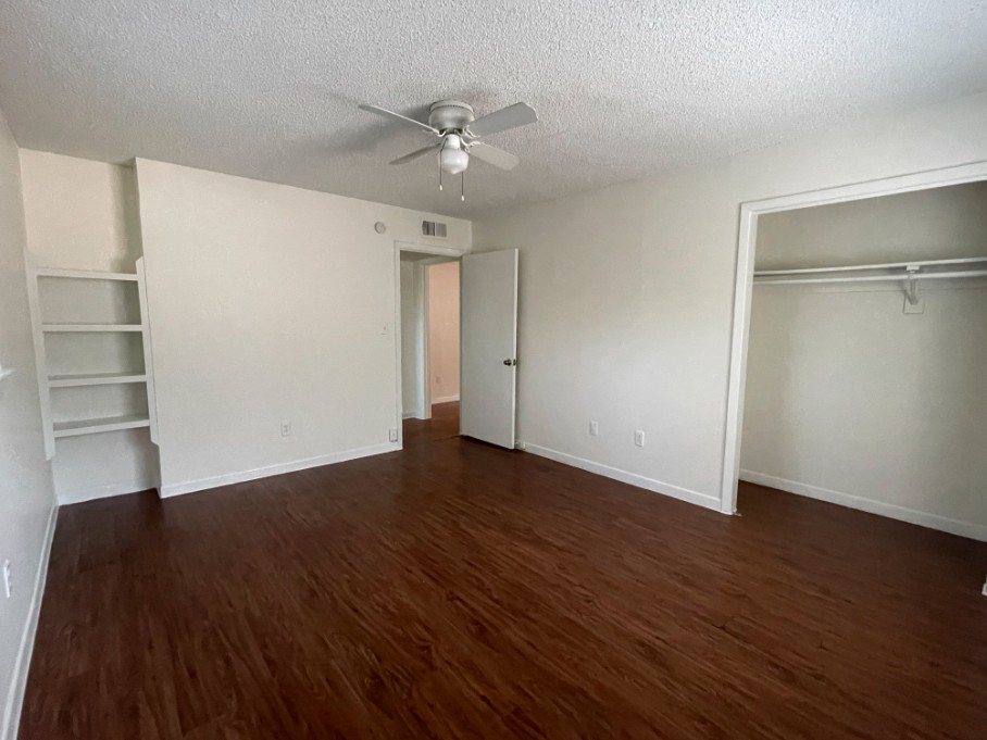 3106 Duval Street, Unit 203 Austin, TX 78705 - Photo 19 of 24 a view of an empty room with wooden floor and a ceiling fan