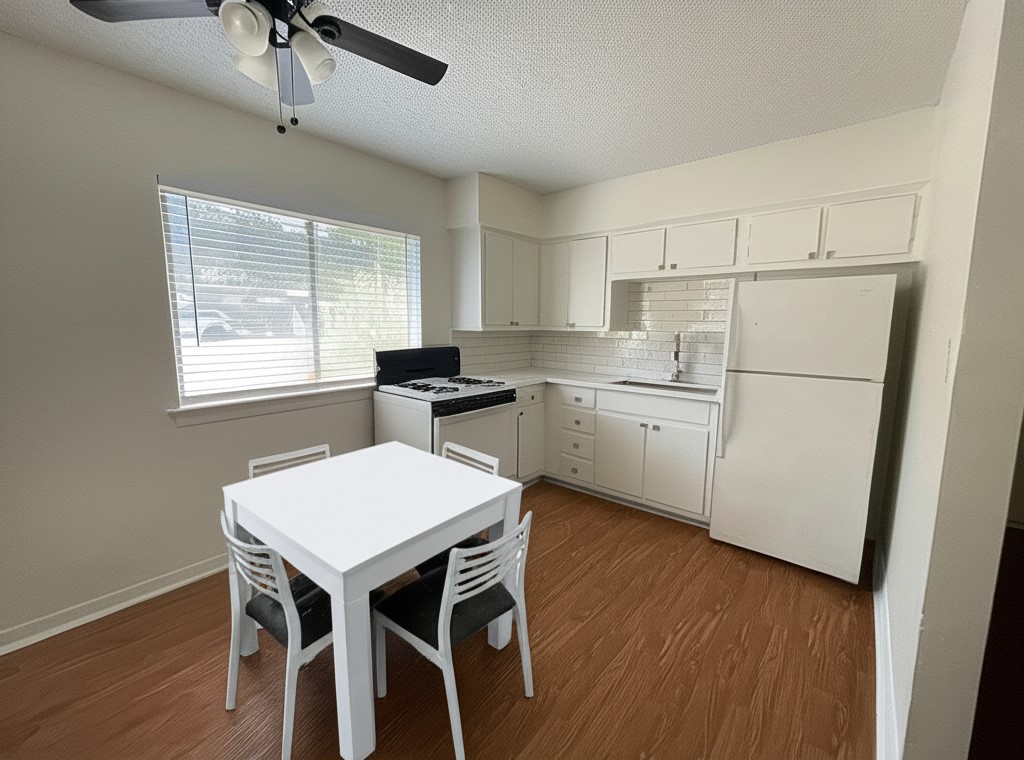3106 Duval Street, Unit 203 Austin, TX 78705 - Photo 6 of 24 a kitchen with a table chairs refrigerator and window