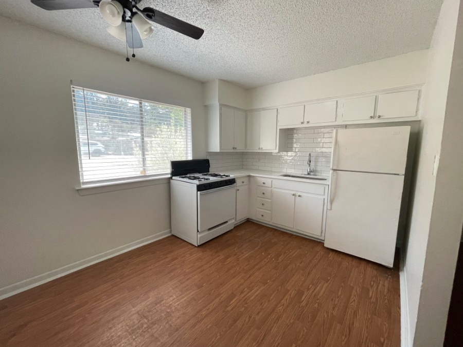 3106 Duval Street, Unit 203 Austin, TX 78705 - Photo 8 of 24 a kitchen with white cabinets and white appliances
