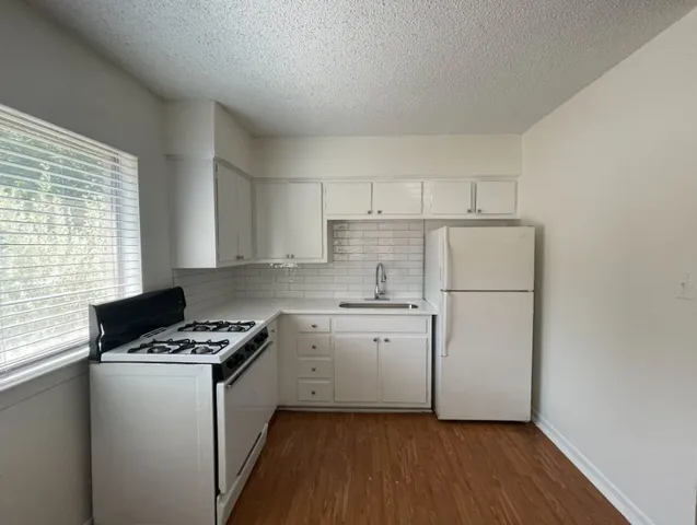 a kitchen with cabinets appliances a sink and a window