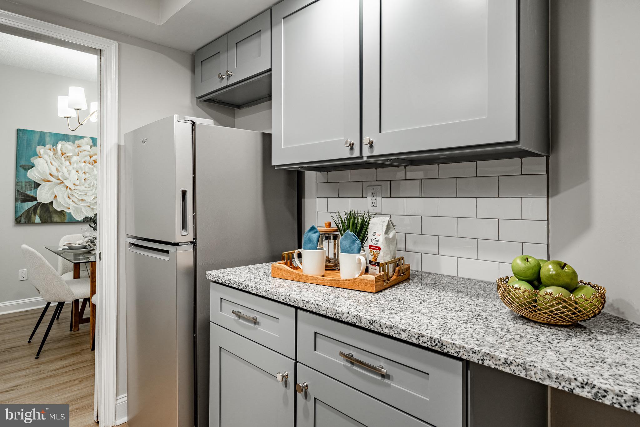 1219 West Wynnewood Road, Unit 105 Wynnewood, PA 19096 - Photo 11 of 34 a kitchen with stainless steel appliances granite countertop a refrigerator and a sink