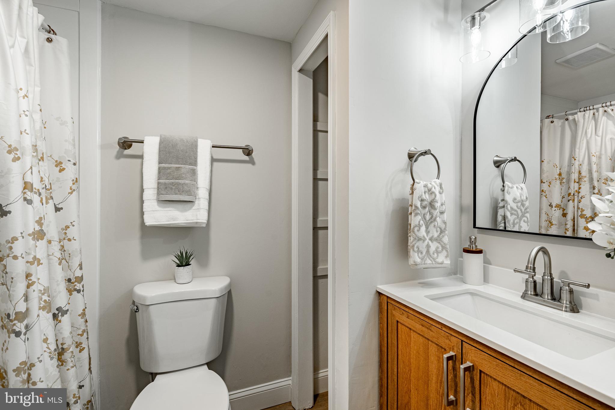 1219 West Wynnewood Road, Unit 105 Wynnewood, PA 19096 - Photo 19 of 34 a bathroom with a toilet sink and mirror