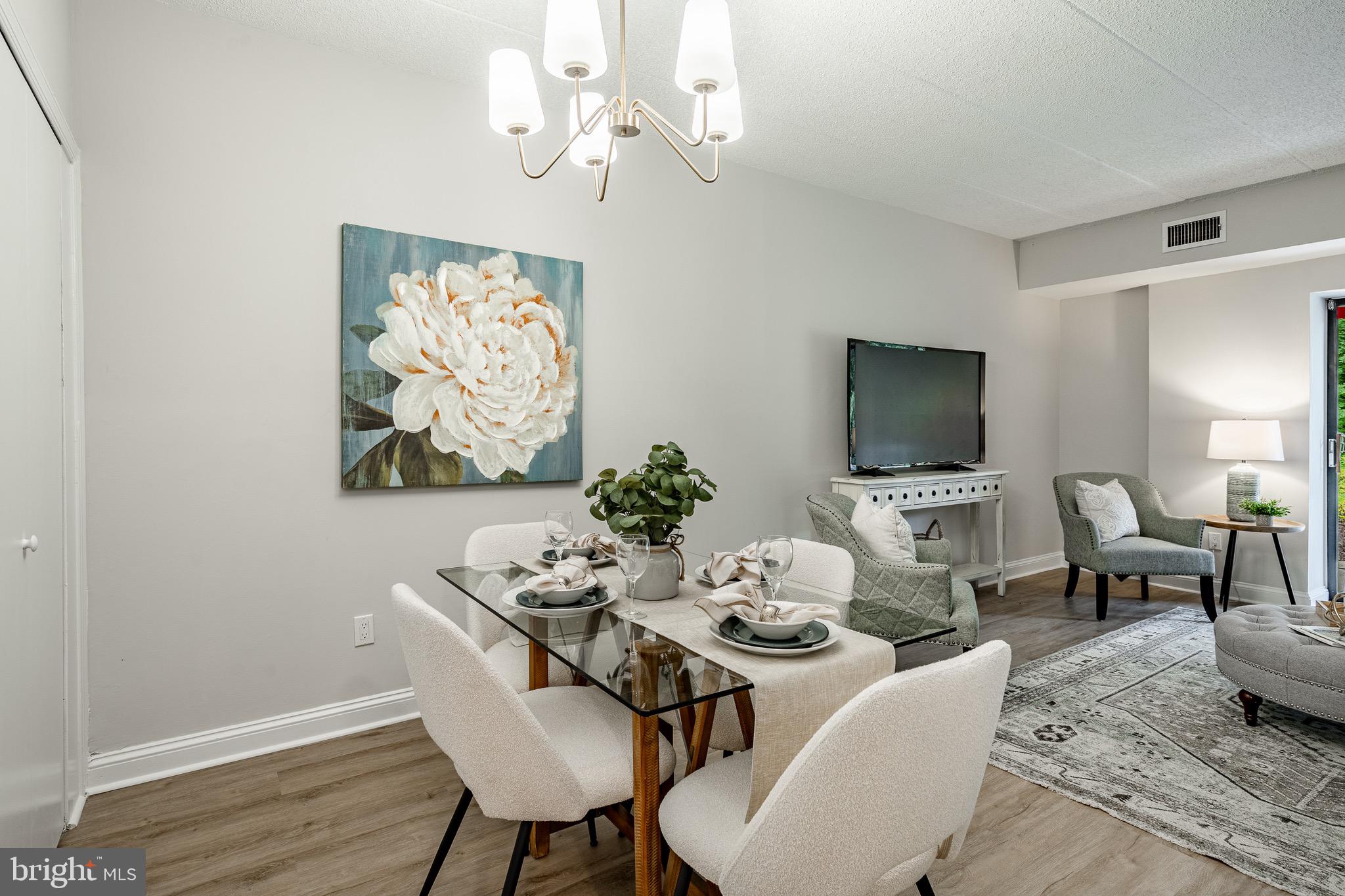 1219 West Wynnewood Road, Unit 105 Wynnewood, PA 19096 - Photo 6 of 34 a view of a dining room with furniture wooden floor and a chandelier