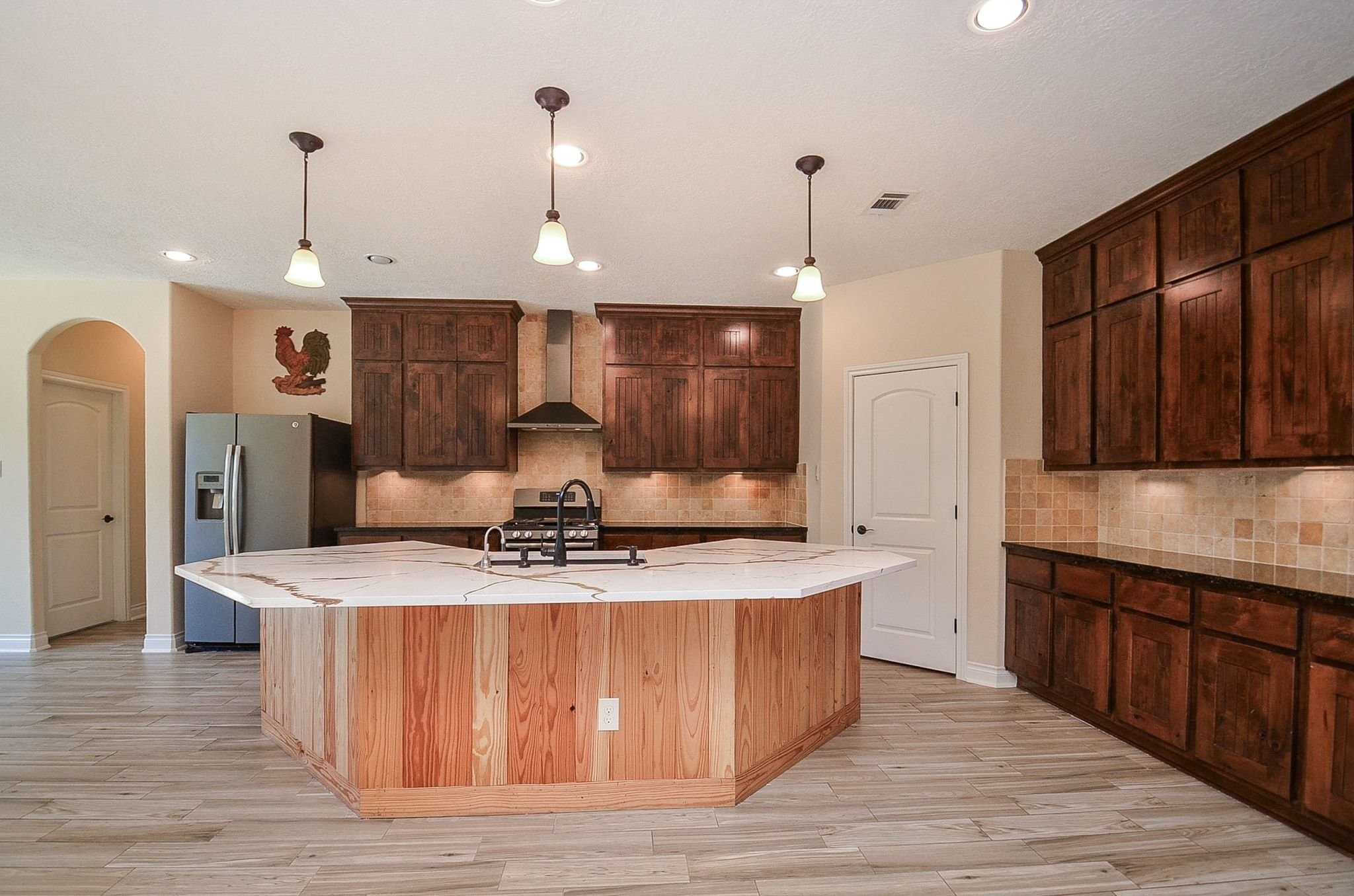 13327 Little Ranch Road Cypress, TX 77429 - Photo 16 of 49 a large kitchen with stainless steel appliances kitchen island granite countertop a stove a sink a refrigerator and a wooden floors