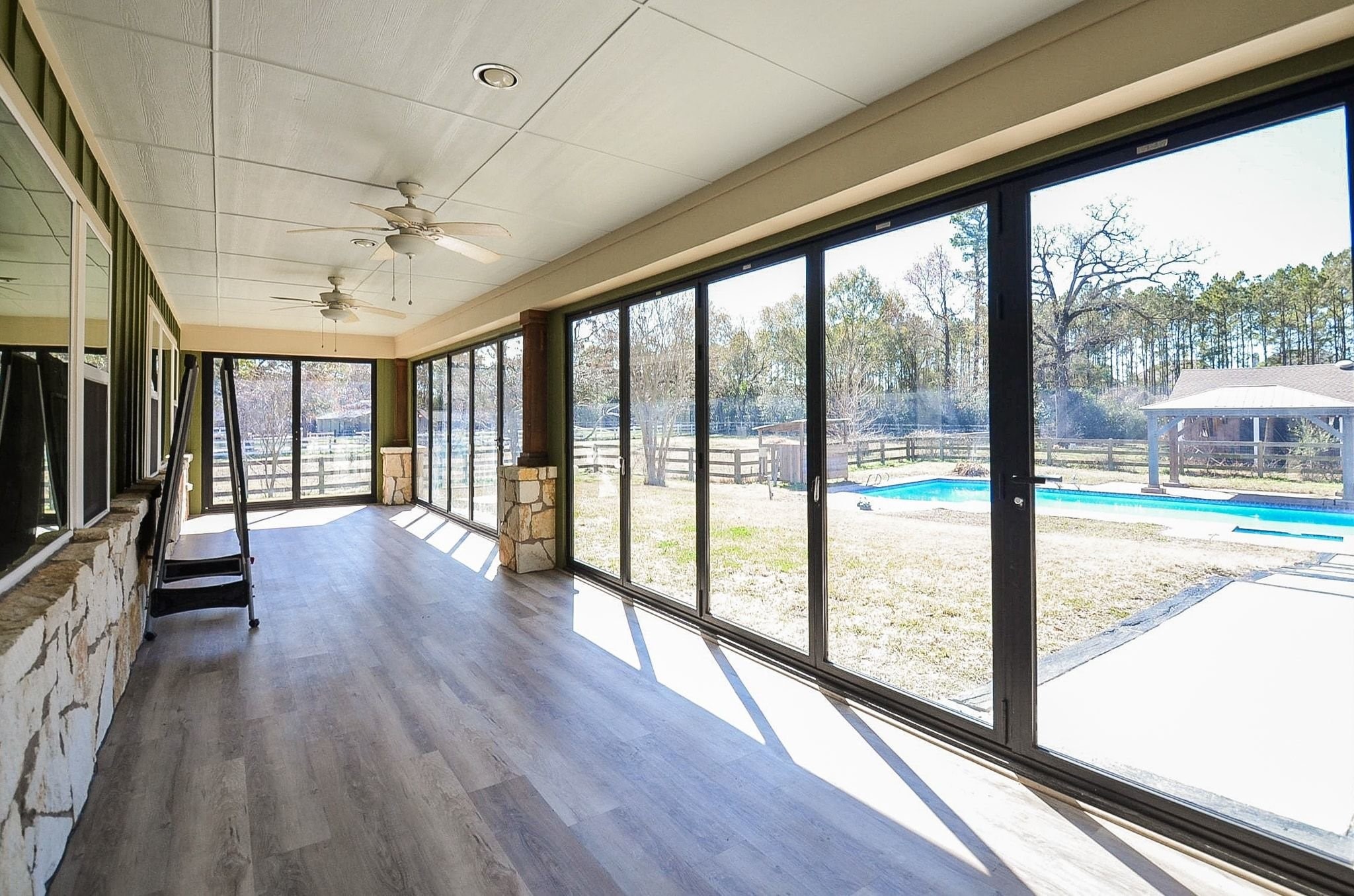 13327 Little Ranch Road Cypress, TX 77429 - Photo 38 of 49 This covered patio features a folding glass door system that opens fully, creating a seamless transition between indoor and outdoor living. When opened, the doors allow abundant natural light and unobstructed views of the backyard and pool area, making the space ideal for entertaining, relaxing, or enjoying year-round outdoor living.