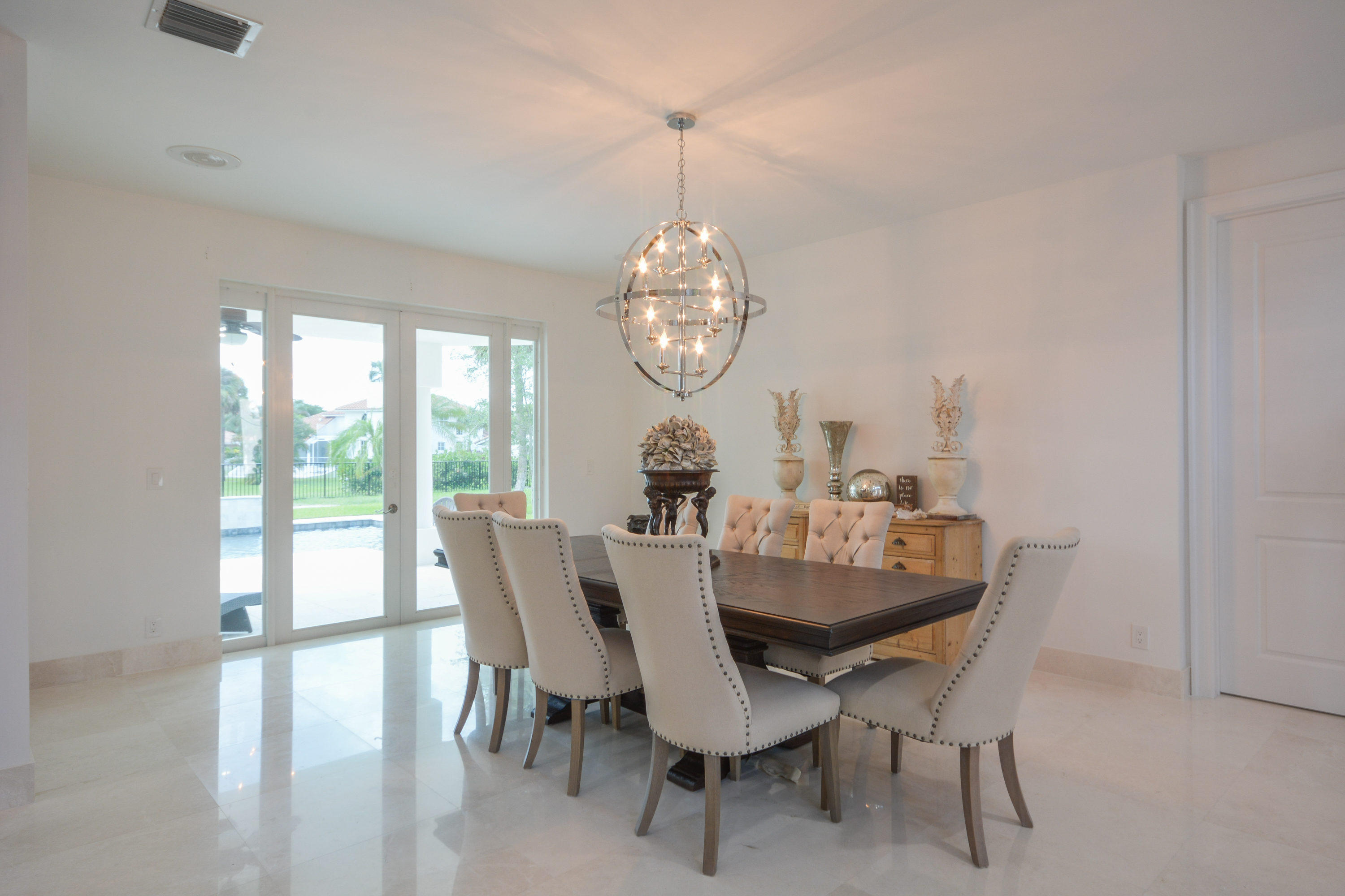 1041 Southwest 21st Avenue Boca Raton, FL 33486 - Photo 21 of 67 a dining room with furniture a chandelier and wooden floor