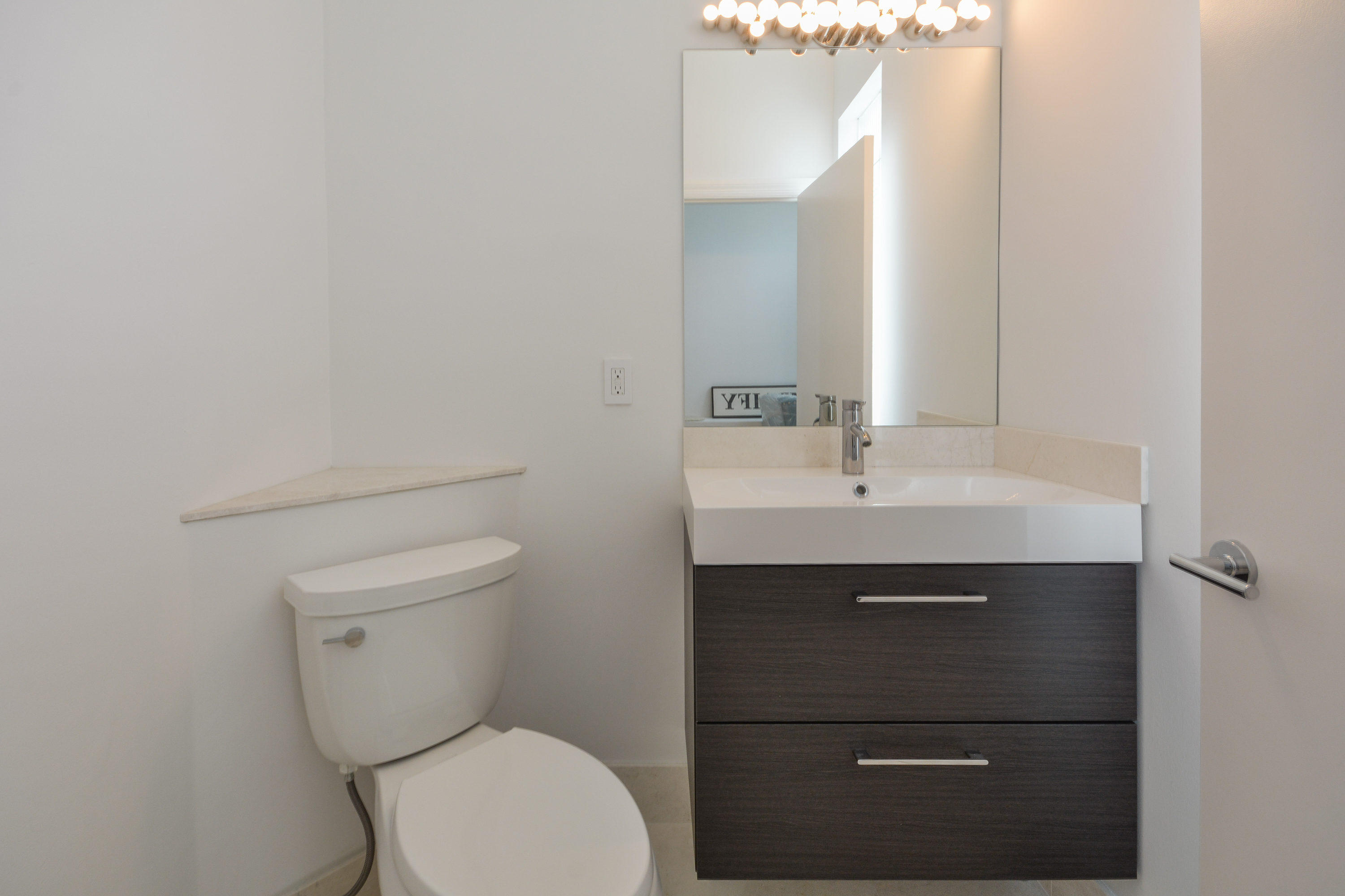 1041 Southwest 21st Avenue Boca Raton, FL 33486 - Photo 33 of 67 a bathroom with a toilet sink and mirror