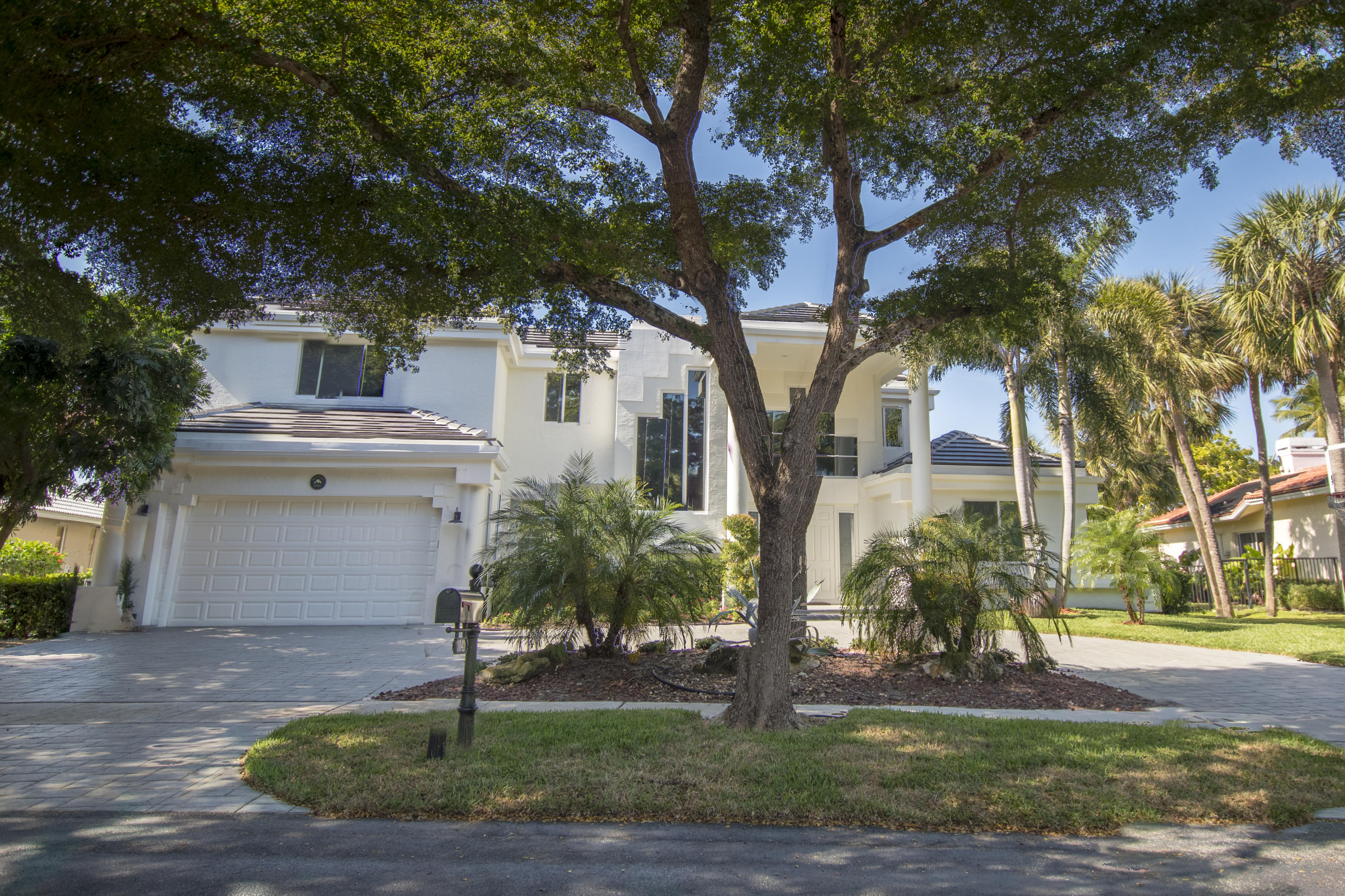 1041 Southwest 21st Avenue Boca Raton, FL 33486 - Photo 58 of 67 a view of a white house next to a road with a large tree