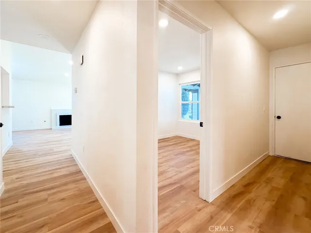 a view of a hallway with wooden floor and staircase