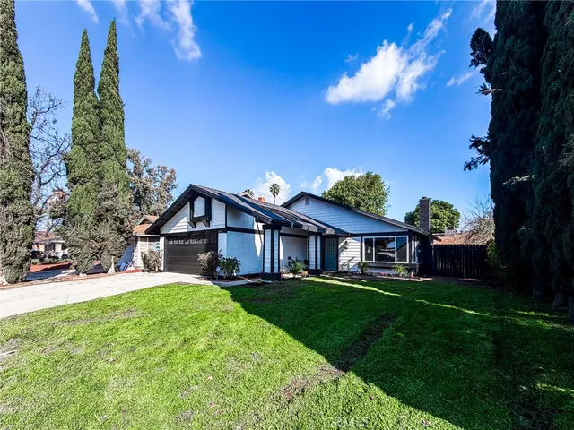 a view of a house with a big yard plants and large trees