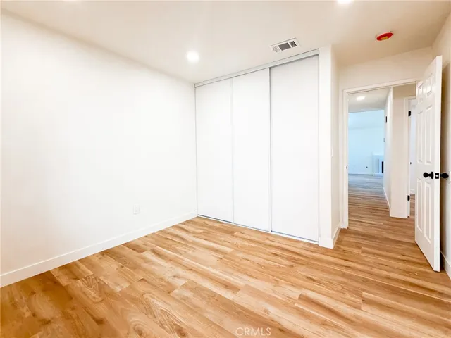 a view of a room with wooden floor and a bathroom