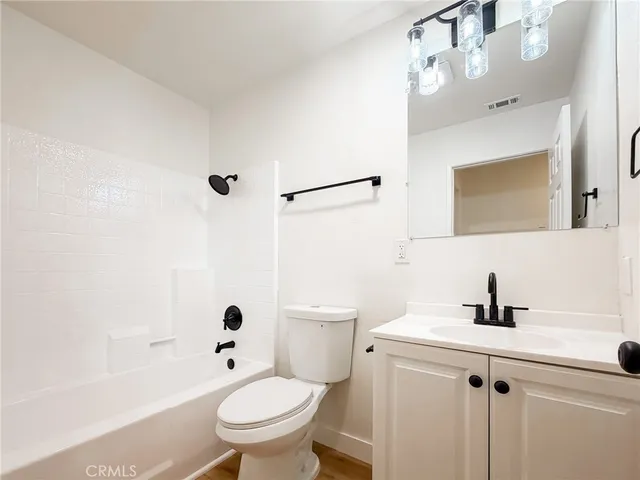 a bathroom with a sink a toilet a mirror and shower