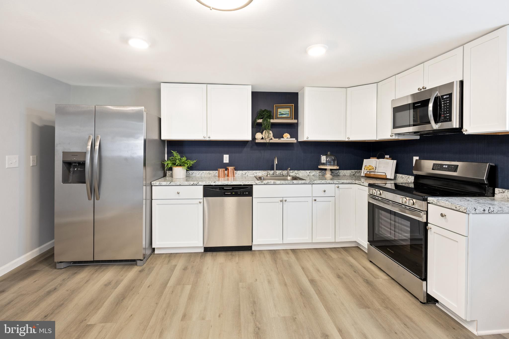 8359 Newark Road Newark, MD 21841 - Photo 19 of 53 a kitchen with white cabinets stainless steel appliances and sink