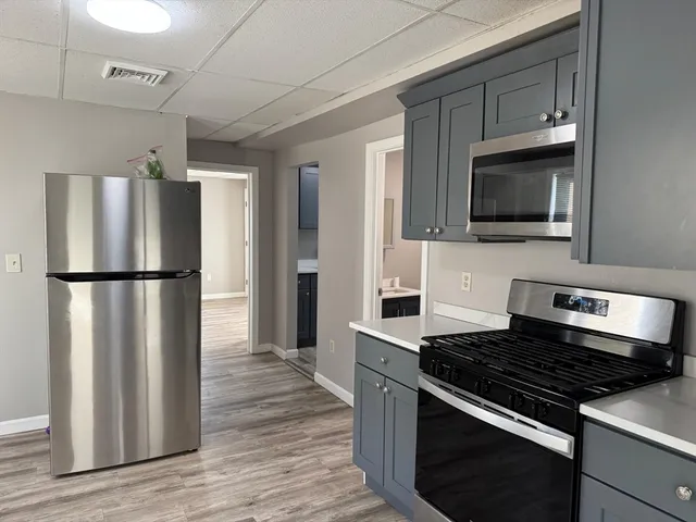 a kitchen with granite countertop a stove and a refrigerator