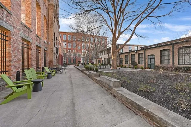 a row of palm trees in front of brick building