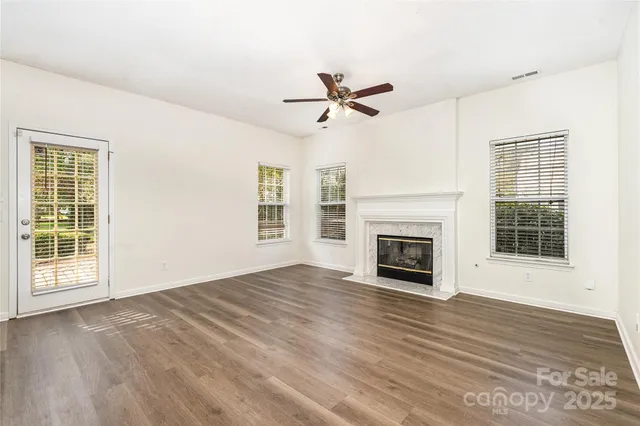 a view of empty room with wooden floor fireplace and windows