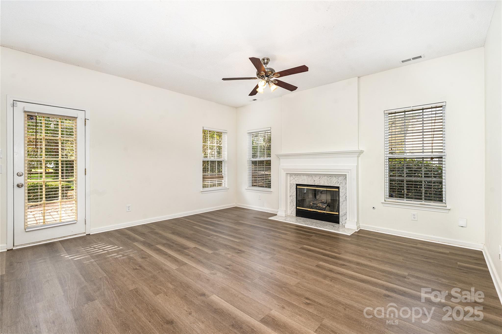 11422 Ridge Oak Drive Charlotte, NC 28273 - Photo 6 of 19 a view of empty room with wooden floor fireplace and windows