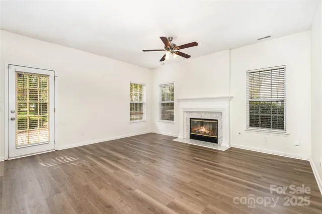 a view of empty room with fireplace and wooden floor