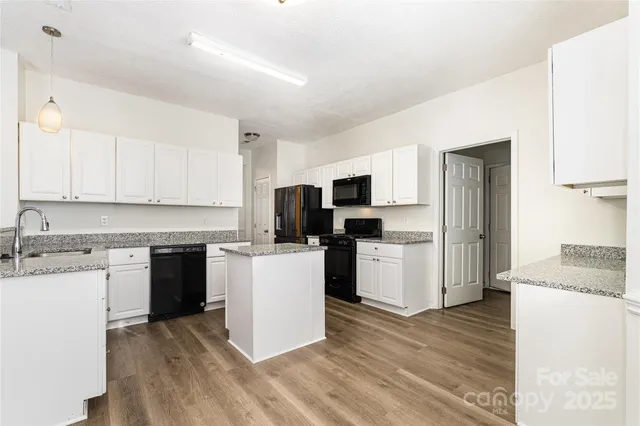 a kitchen with stove top oven and refrigerator