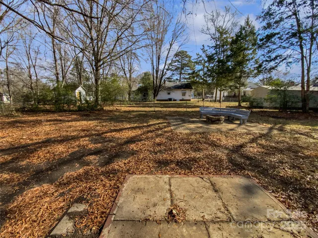 a view of dirt yard with a large tree