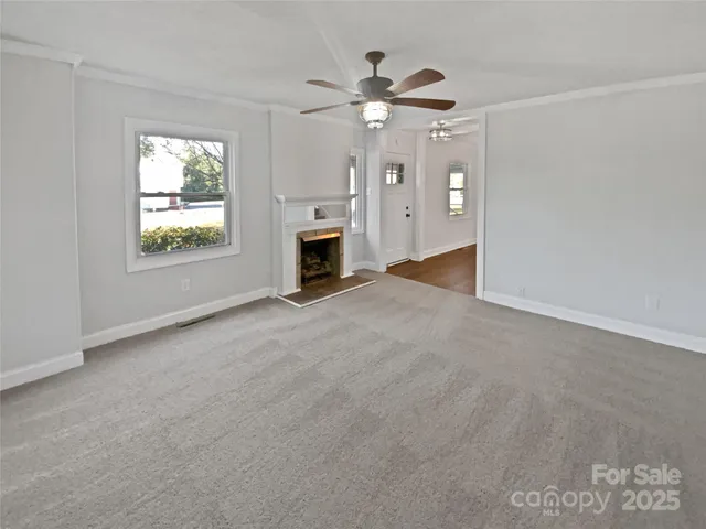 a view of a livingroom with a ceiling fan window and a ceiling fan