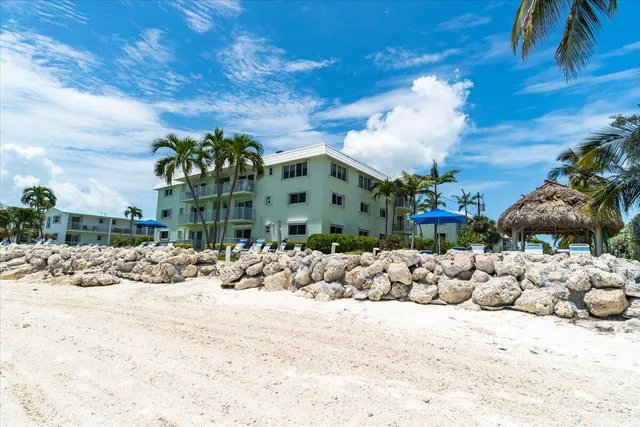 a view of a patio with dining table and chairs under an umbrella with a fire pit
