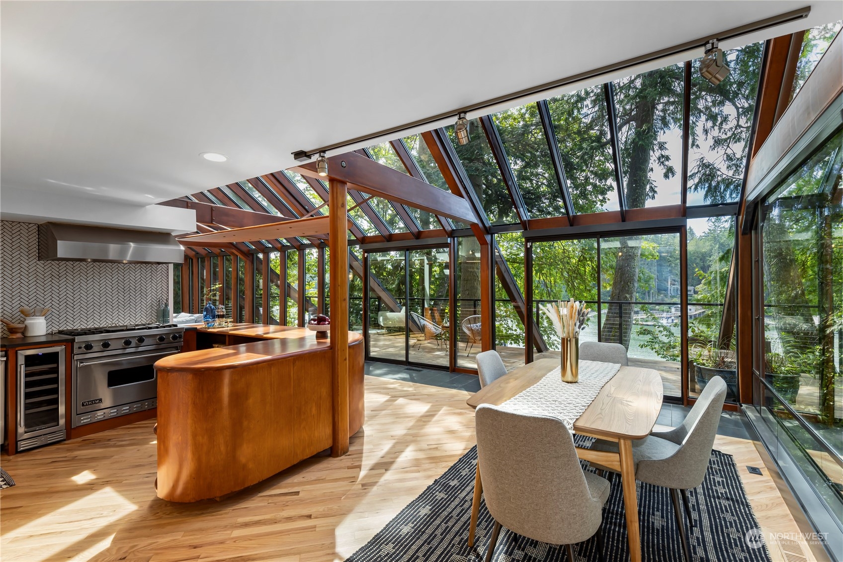 8100 Northeast Hidden Cove Road Bainbridge Island, WA 98110 - Photo 13 of 37 a view of a dining room with furniture large windows and wooden floor