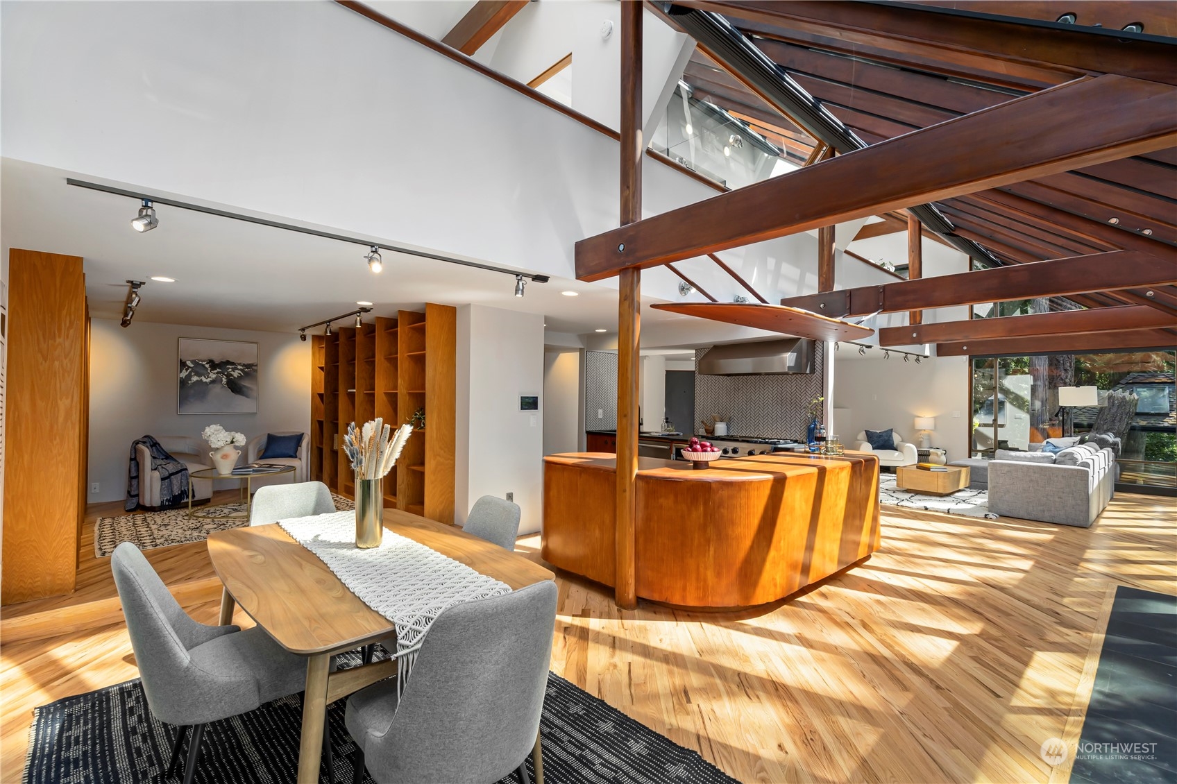 8100 Northeast Hidden Cove Road Bainbridge Island, WA 98110 - Photo 14 of 37 a view of a dining room with furniture a chandelier and wooden floor