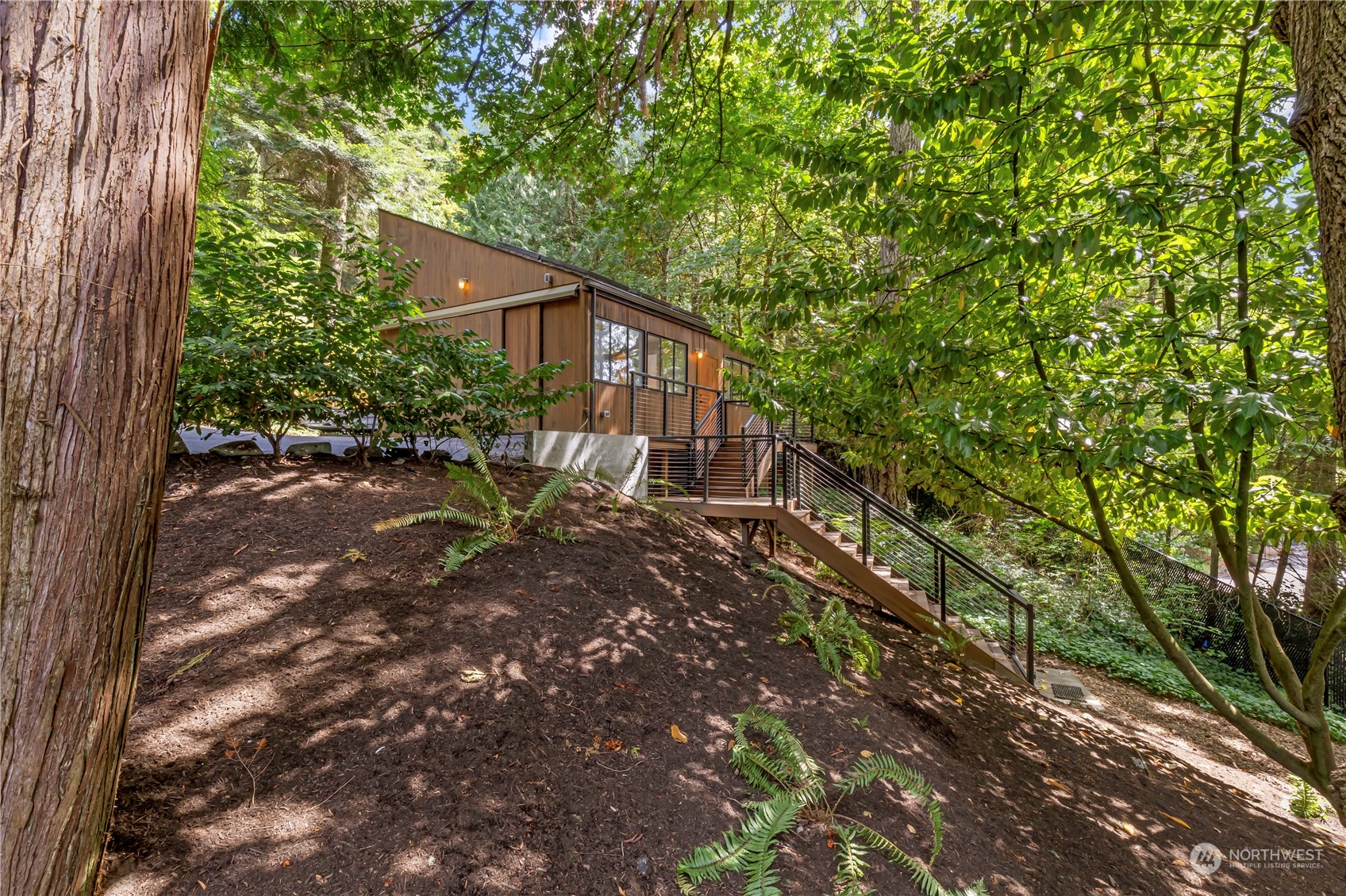 8100 Northeast Hidden Cove Road Bainbridge Island, WA 98110 - Photo 21 of 37 a backyard of a house with table and chairs