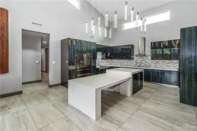 a large kitchen with stainless steel appliances kitchen island granite countertop a sink and cabinets
