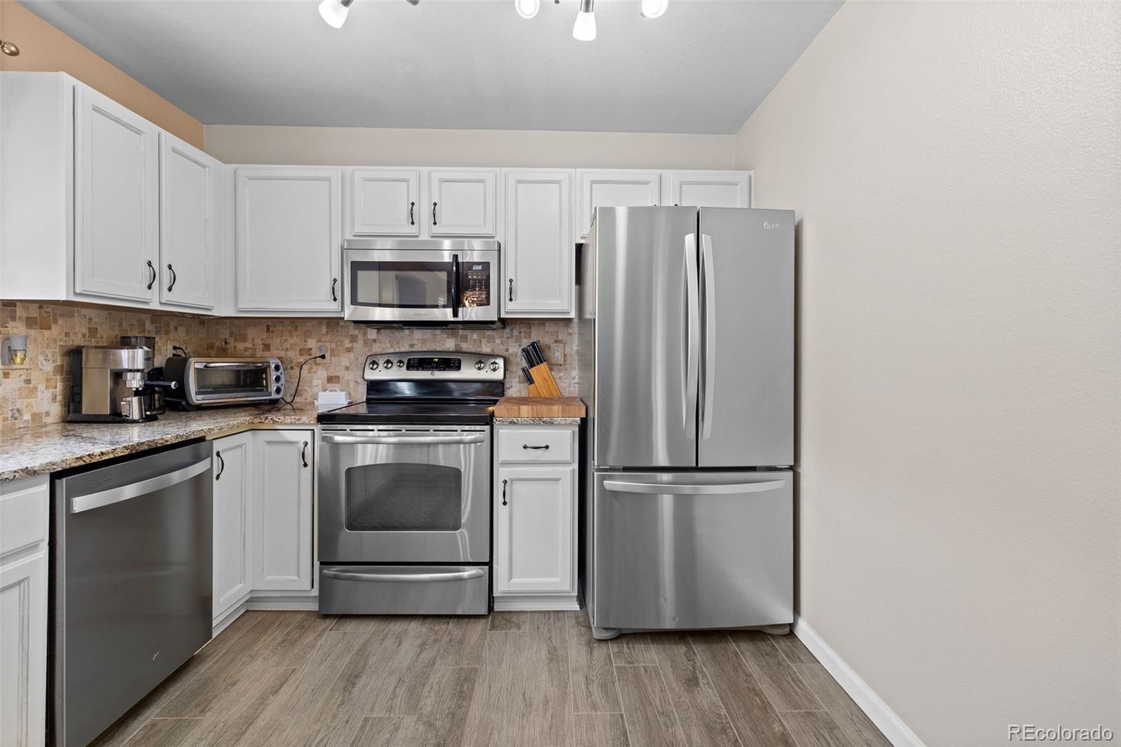 10565 Hyacinth Place Highlands Ranch, CO 80129 - Photo 13 of 33 a kitchen with a refrigerator and a stove top oven