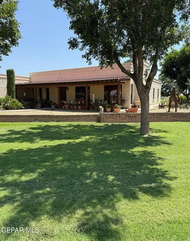 a front view of a house with garden and sitting area