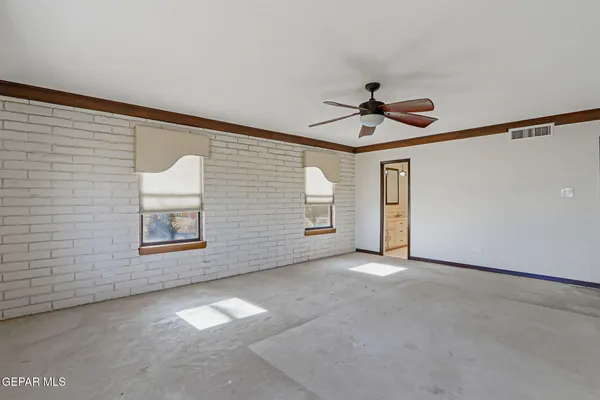 a view of a bedroom with wooden floor and windows